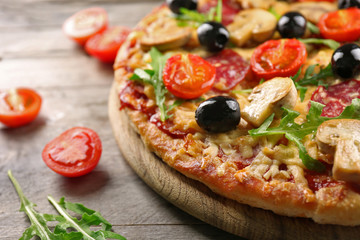 Delicious tasty pizza with ingredients on wooden table