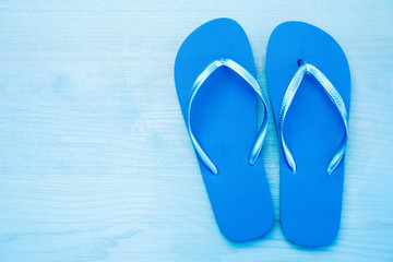 Fototapeta premium Color flip flops on blue wooden background