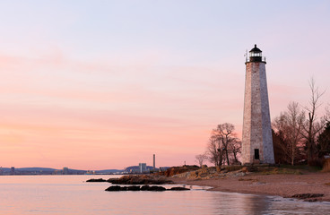 New Haven Light House at Lighthouse Point Park At Sunset. The lighthouse is dark, but the tower...