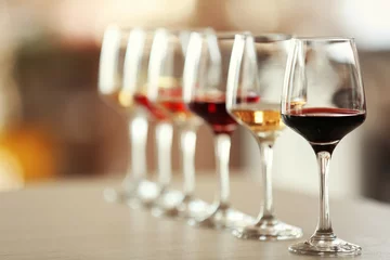 Fototapete Wein Viele Gläser unterschiedlichen Weins hintereinander auf einem Tisch