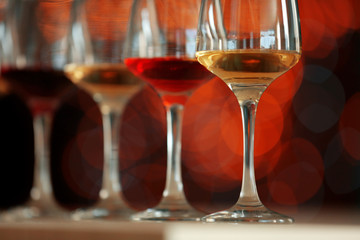 Many glasses of different wine in a row on a table
