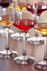 Many glasses of different wine in a row on a table