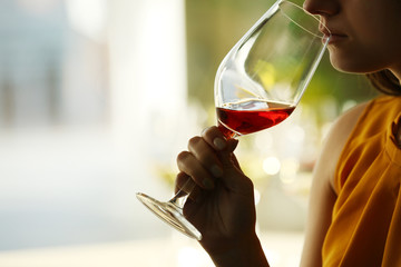 Woman sniffing red wine in a glass, close up