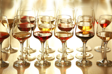 Many glasses of different wine in a row on a table
