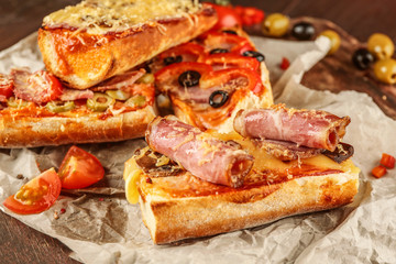 Hot pizza baguette with bacon and cheese on wooden table