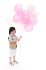 Asian child holding pink and white balloons