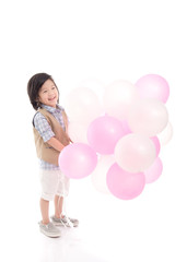 Fototapeta na wymiar Asian child holding pink and white balloons