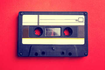 Old audio cassette on red background