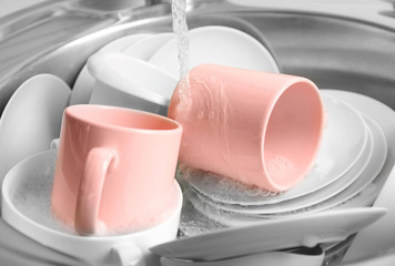 Pile of dishes in sink closeup