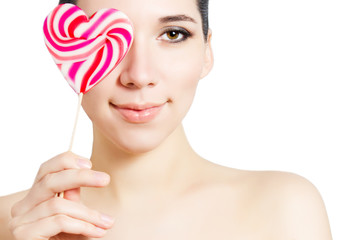 Portrait of a young attractive girl with a lollipop in the shape