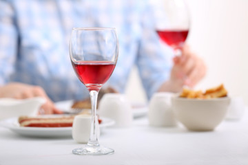 Dinner with glasses of wine on light blurred background