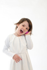 Sweet girl amazed screaming at toy phone on white background