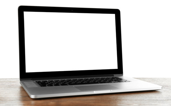 Laptop with black screen on wooden table against white background