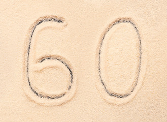 60 number written on beach sand. Summer background