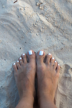 Bare feet girl on white sand