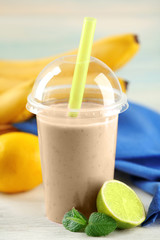 Banana cocktail and fresh fruits on wooden table