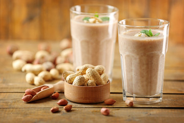 Fresh banana cocktail with peanuts on wooden table