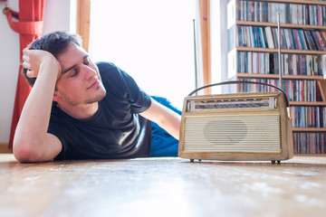 Junger Mann hört Musik mit altem Radio