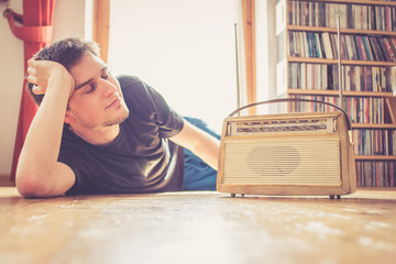 Junger Mann hört Musik mit altem Radio