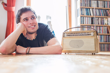 Junger Mann hört Musik mit altem Radio