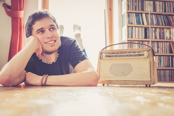 Junger Mann hört Musik mit altem Radio