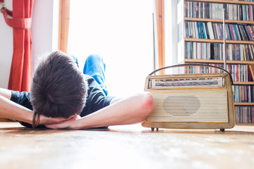 Junger Mann hört Musik mit altem Radio