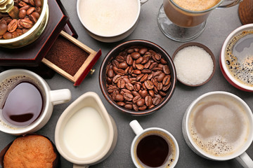 Different types of coffee in cups on dark table, top view