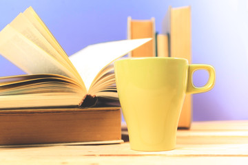 Color cup of tea with books on table