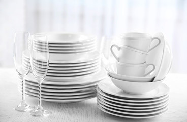 Set of new white dishes on wooden table, indoors