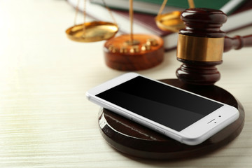 Gavel and smartphone on wooden background