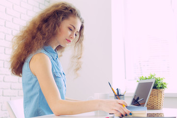 Beautiful caucasian woman sitting  and working on laptop
