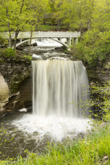 Minneopa Falls / A waterfall with a footbridge during spring.