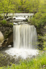 Obraz premium Minneopa Falls / A waterfall with a footbridge during spring.