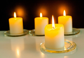 closeup to burning candles in darkness