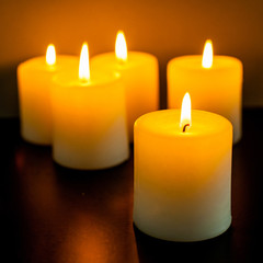 closeup to burning candles in darkness
