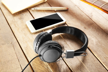 Headphones and smartphone on wooden background