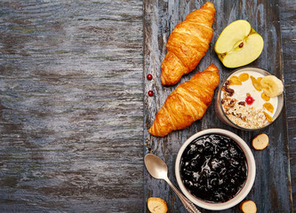  Healthy eating concept. Healthy breakfast with yogurt and croissant, cereals, jam, fruit. Top view, copy space