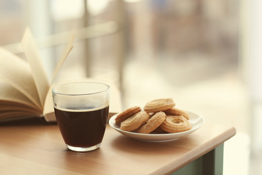 Cup Of Coffee And Book On The Table In Cafe