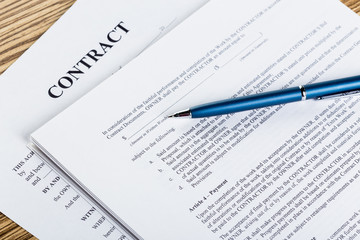 Obraz premium Pen and contract papers on wooden desk