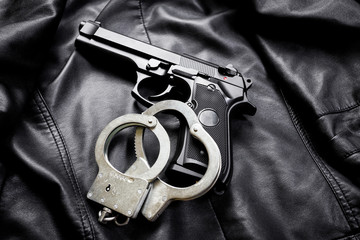 Rifle, gun, knife with sheath, compass and notebook with pen on on black cloth