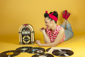Portrait beautiful pin up listening to music on an old jukebox r