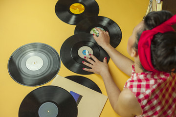 Rear view portrait pin up girl with old vinil records. Selective