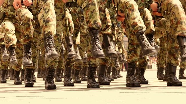 Soldiers marching in a parade through the town in slow motion,  Slow Motion Video Clip