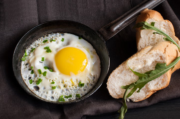 Fried egg in pan and sliced loaf