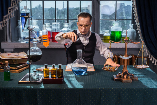 The vintage laboratory Scientist chemicals mixed in a round bottom flask and the solution was blue