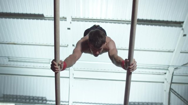  Professional male gymnast training on parallel bars at the gym