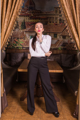 Young gorgeous businesswoman standing in restaurant interior.