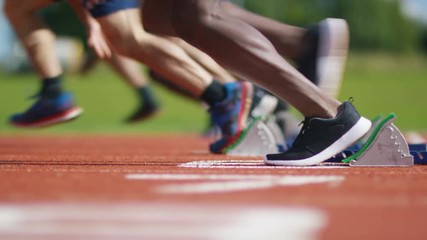  Group of athletes at running track, crouch at starting line before a race