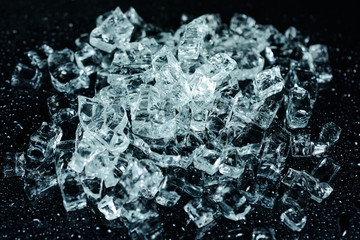 background with crushed ice cubes on reflection table with water drops. selective focus