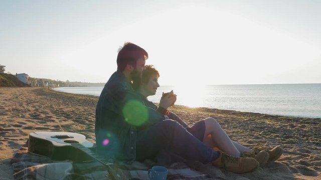 happy loving couple on beach. Young man and woman enjoying the sunset or sunrise